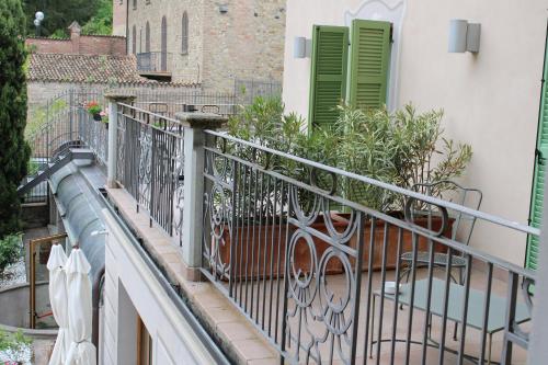 a balcony with a railing and green doors and plants at Cora Hotels Leon d'Oro in CastellʼArquato
