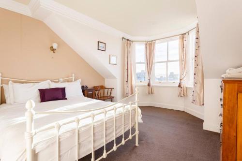 1 dormitorio con cama blanca y ventana en Lochinver, en Crieff