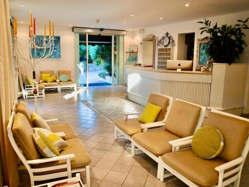 un hall avec des chaises et un bar avec un comptoir dans l'établissement Hotel Meridiana, à Marina di Campo