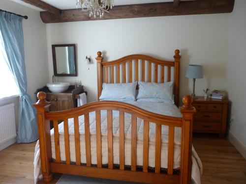 a bedroom with a wooden bed and a mirror at Hawthorn Cottage in Greencastle