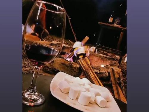 una copa de vino junto a un plato de malvaviscos y una copa en Hospedaje Guatavita cabaña tippie, en Guatavita