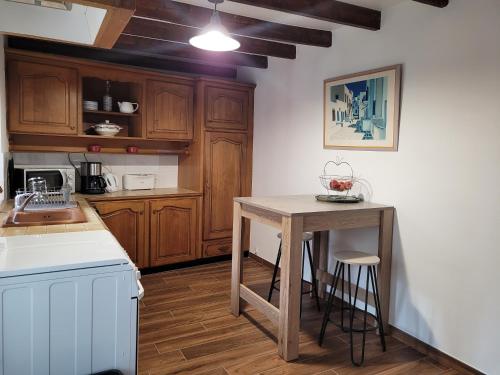 une cuisine avec des armoires en bois et une table en bois dans l'établissement le Milin Du, à Gouarec