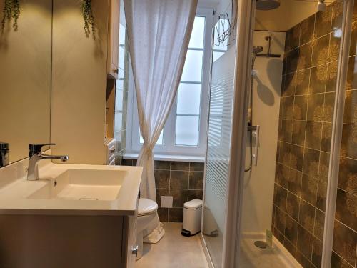 La salle de bains est pourvue d'un lavabo, de toilettes et d'une fenêtre. dans l'établissement le Milin Du, à Gouarec