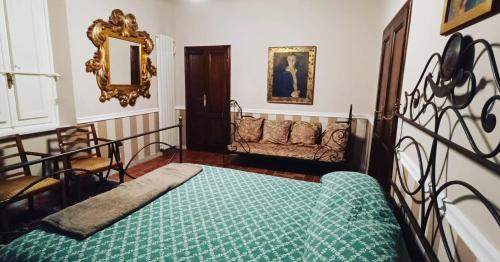 een slaapkamer met een bed en een bank bij Villa Marinsky Pietrasanta , Lucca in Pietrasanta