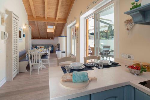 a kitchen and living room with a table and a dining room at Attico con vista sul lago e montagne a Molveno in Molveno