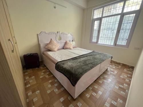 Schlafzimmer mit einem Bett und einem Fenster in der Unterkunft HILLS HOME in Shimla