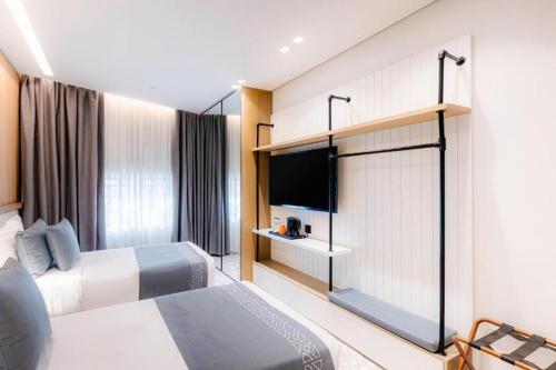 a hotel room with two beds and a flat screen tv at Assaafa Hotel in Al Madinah