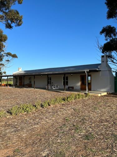 a white building with a black roof at Lamb’s Inn in Bredasdorp