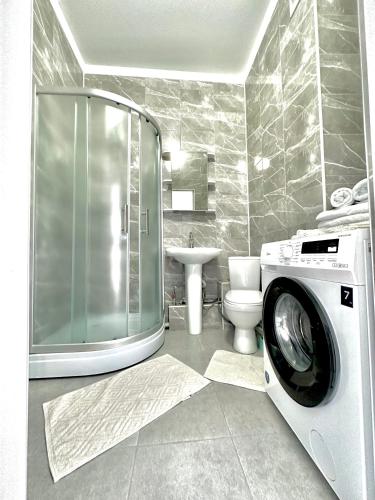 ein Badezimmer mit einer Waschmaschine und einem WC in der Unterkunft Жилой комплекс Гранд Туран in Taldykolʼ
