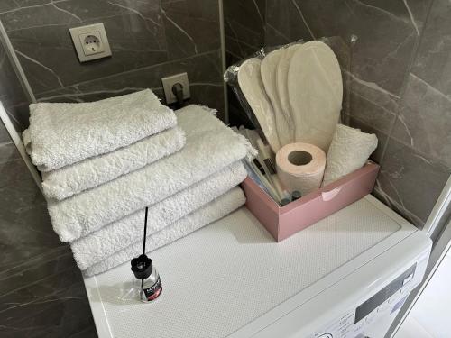 einen Haufen Handtücher auf einem Regal im Bad in der Unterkunft Жилой комплекс Гранд Туран in Taldykolʼ