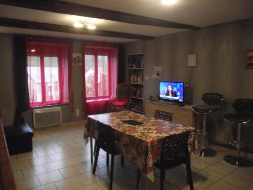 a living room with a table and a tv at Maison chez Coco in Nouzonville