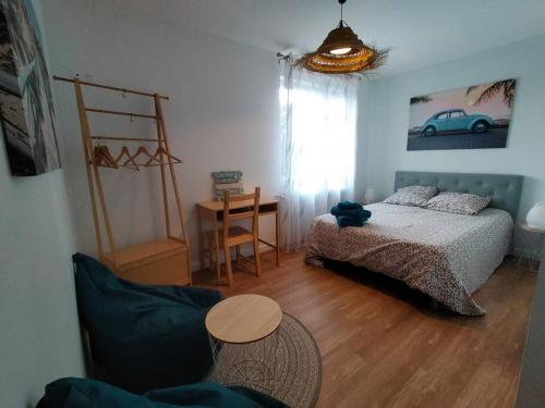 sypialnia z łóżkiem i stołem w obiekcie Maison et parking privé proche zénith et volcans. w mieście Le Cendre