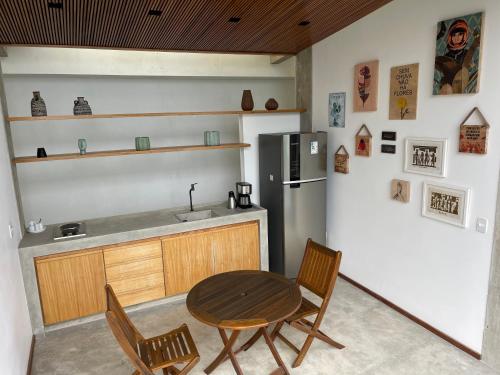 a kitchen with a table and chairs and a refrigerator at Verde Mar Pousada in Angra dos Reis