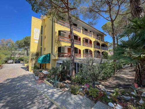 żółty budynek z balkonami od strony ulicy w obiekcie Hotel Meridiana w mieście Marina di Campo