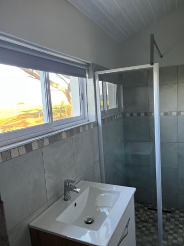 a bathroom with a sink and a shower at Lamb’s Inn in Bredasdorp