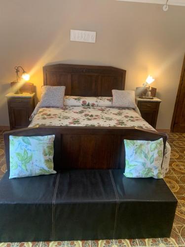 a bedroom with a large bed with a wooden headboard at Bouganville in Viverone