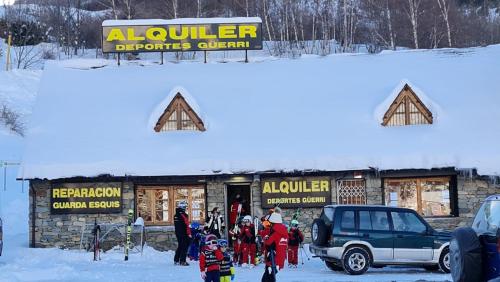 a group of people standing outside of a building in the snow at Tuhogarencerler parking y taquilla en pistas in Cerler