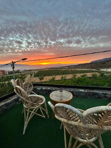 a patio with chairs and a table and a sunset at La Cabaña in Guía de Isora