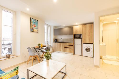 a living room with a table and a kitchen at le Roche in Toulon