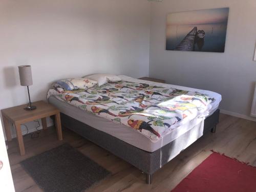 1 dormitorio con 1 cama y 1 mesa con lámpara en Lycke - By the sea, en Lycke