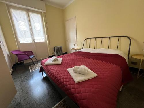 a bedroom with a red bed with towels on it at LIGURIA HOLIDAYS - "La Casa di Gisella" in Camogli