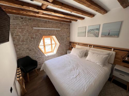 a bedroom with a bed and a brick wall at On the Square Suites in Split