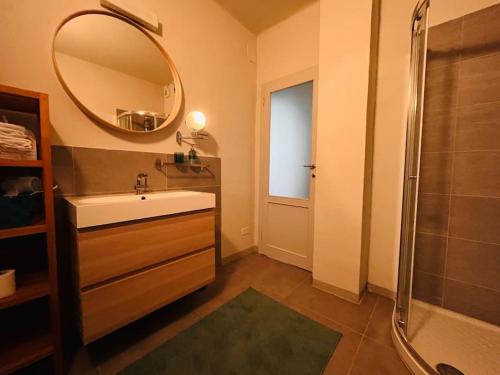 a bathroom with a sink and a shower and a mirror at Appartamento 109 con giardino esclusivo in Lucca