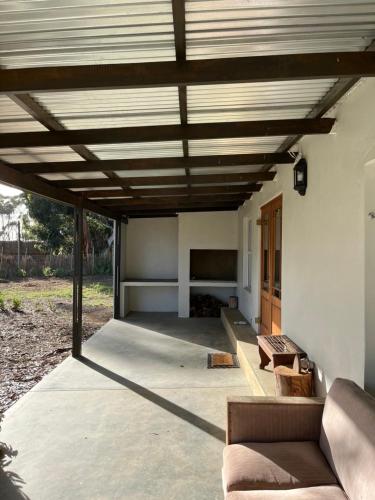 a patio with a wooden ceiling and a couch at Lamb’s Inn in Bredasdorp