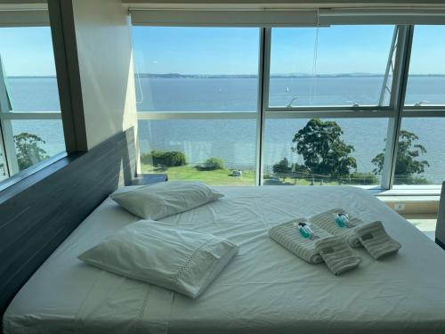 a large white bed with towels and pillows on it at Loft com vista incrível no Barra Shopping in Porto Alegre