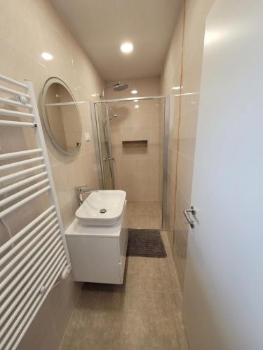 a white bathroom with a sink and a shower at The Setting Sun in Umag