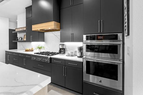 a kitchen with black cabinets and stainless steel appliances at Highland Harmony New Listing Intro Pricing in Highland Haven