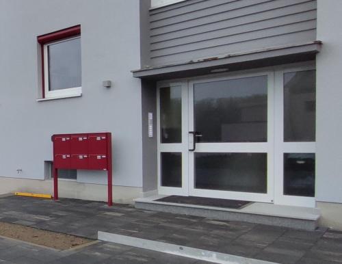 a door to a building with a red box in front at Berg Apartments in Oberreichenbach