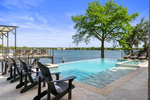 a swimming pool with chairs and a tree and water at Highland Harmony New Listing Intro Pricing in Highland Haven