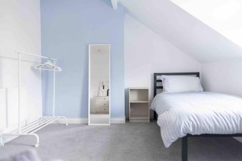 a white bedroom with a bed and a mirror at Charming 3 bedroom Belfast townhouse in Belfast