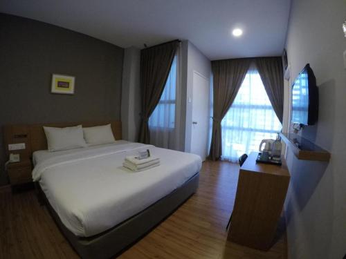 a hotel room with a bed and a television at Golden Leaf Boutique Hotel Nusa Idaman Formerly Known as Ariana Hotel in Johor Bahru