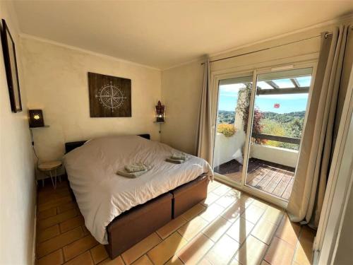Un dormitorio con una cama y una ventana grande. en belle villa, piscine, jacuzzi, en Six-Fours-les-Plages