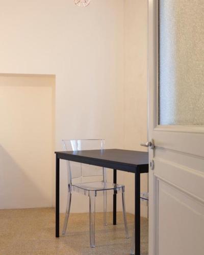 a black table with a chair next to a door at Relais Flora Arzo Appartamento superior di vacanza con posteggio in Mendrisio