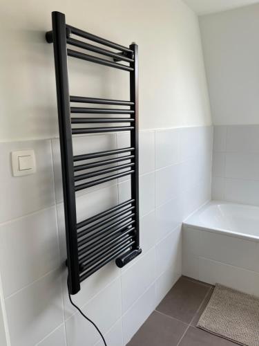 a shower with a black towel rack in a bathroom at Casa Vista Verde in De Panne