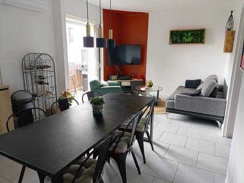ein Wohnzimmer mit einem Tisch und einem Sofa in der Unterkunft Appart. 3ch - 6mn de la plage de Bonne Grâce in La Seyne-sur-Mer