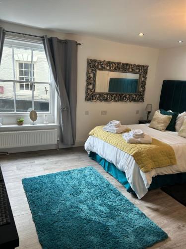 a bedroom with two beds and a blue rug at Market View 1 in Hexham