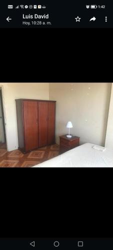 Schlafzimmer mit einem Bett und einem Holzschrank in der Unterkunft Departamentos de la Costa in Machala