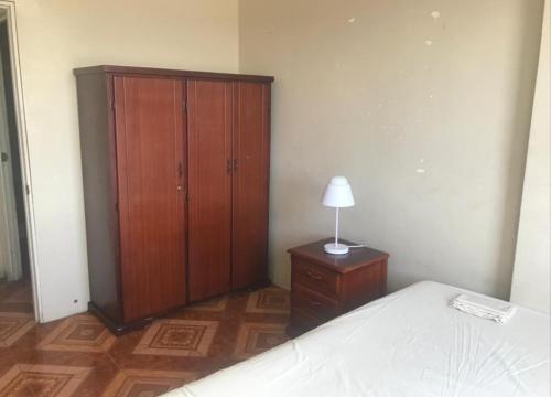 - une chambre avec un lit et une armoire en bois dans l'établissement Departamentos de la Costa, à Machala