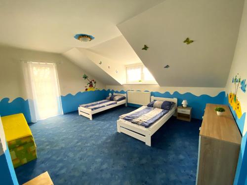 2 camas en una habitación con alfombra azul en Rekreační chalupa Ivon, 