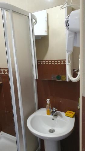 a bathroom with a white sink and a shower at Seaview, just across the beach, Bečići in Bečići