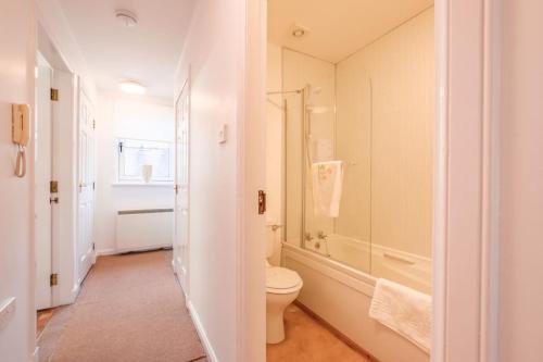 a white bathroom with a toilet and a shower at Station Apartment 1 bed- Lanark in Lanark