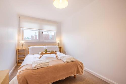 a bedroom with a bed with a table on it at Station Apartment 1 bed- Lanark in Lanark