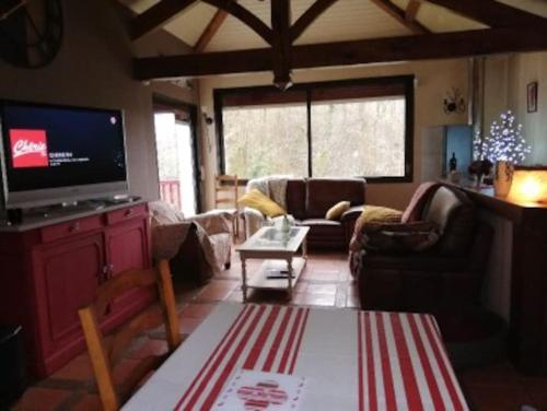 un salon avec des canapés et une télévision à écran plat dans l'établissement Maison de charme Nature et Rivière au pays basque, à Estérençuby