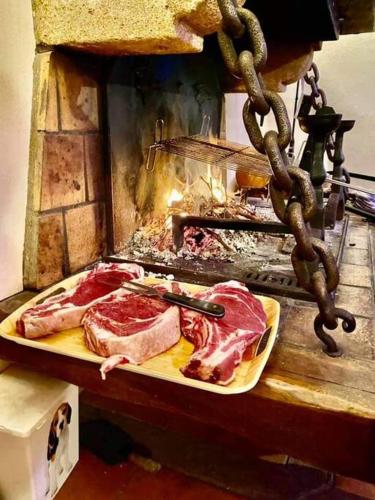 un grill avec de la viande sur une planche à découper dans l'établissement Maison de charme Nature et Rivière au pays basque, à Estérençuby