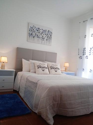 a bedroom with a bed with two pillows on it at Chalas place in Nazaré