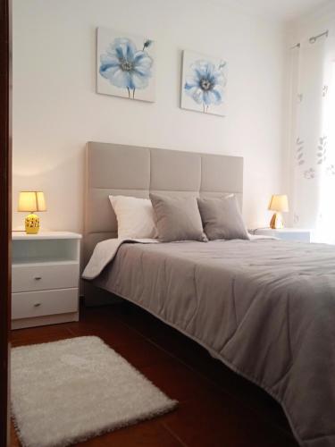 a bedroom with a bed with two pictures on the wall at Chalas place in Nazaré